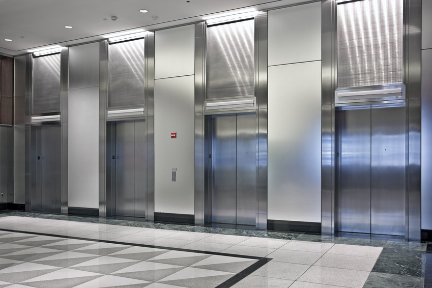Luxury elevator cab interior with reflective metal and warm lighting